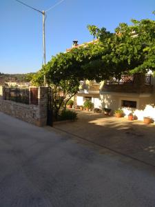 a tree in front of a building with a fence at Villa Sunset in Samos