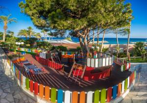 a playground at the beach with a colorful fence at Amathus Beach Hotel Limassol in Limassol