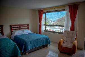 um quarto com uma cama, uma cadeira e uma janela em Guayacan Hotel - Pedregal Rio 
