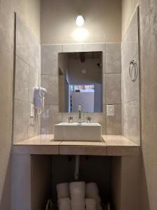 een badkamer met een wastafel, een spiegel en handdoeken bij Tierra Primitiva in Tilcara