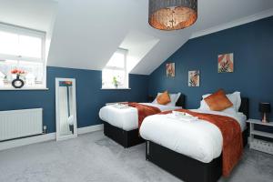 Duas camas num quarto com paredes azuis em Serene Escape, Perfect Location in Canterbury Free Parking em Chartham