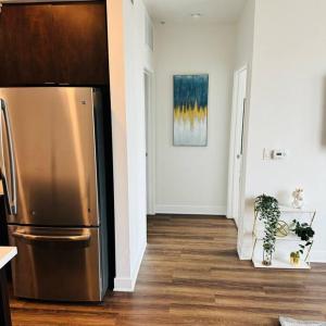 a kitchen with a stainless steel refrigerator in a room at Luxury Condo with Pool & Gym ! in Glendale