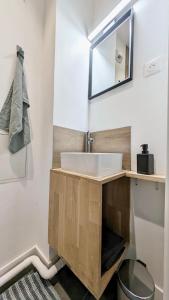 y baño con lavabo y espejo. en Immeuble de 4 appartements à thèmes, en Abbeville