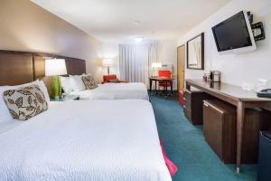 una camera d'albergo con 2 letti e una scrivania di Alliance Hotel and Suites ad Alliance