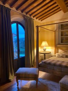 a bedroom with a bed and a table and a window at Il Borghetto Andrea Tafi in Lamporecchio