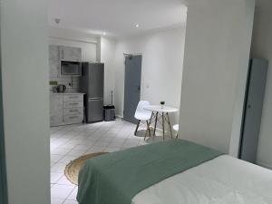 a bedroom with a bed and a kitchen with a table at Cavendish Suite Bachelor in Cape Town