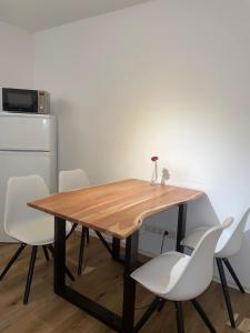 una mesa de comedor con sillas blancas alrededor en TRUST Hotel & Apartment, en Stuttgart