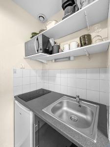 uma cozinha com um lavatório e uma bancada em Charme Citadin Angevin - hyper centre Angers em Angers