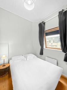 um quarto com uma cama branca e uma janela em Charme Citadin Angevin - hyper centre Angers em Angers