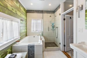 een badkamer met een bad, een douche en een wastafel bij Barclay Klum House by WanderLodges in Ashland