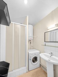 uma casa de banho branca com uma máquina de lavar roupa e um lavatório em Charme Citadin Angevin - hyper centre Angers em Angers