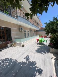 a patio with a green table and benches on a building at Hotel Villa Flowers 2 in Vlorë +5 photos