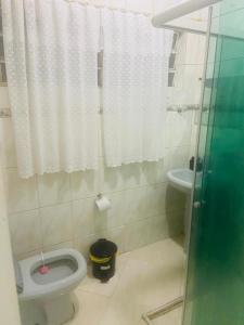 La salle de bains est pourvue de toilettes et d'un lavabo. dans l'établissement CASA FAMÍLIA PRÓXIMO À BASÍLICA, à Aparecida