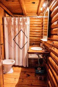 un bagno con un water e una tenda da doccia di Altos de PehuenCo a Balneario Pehuén-Có