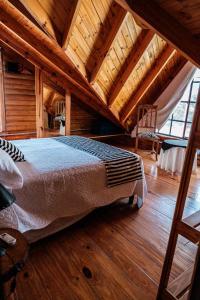 un letto grande in una stanza con soffitto in legno di Altos de PehuenCo a Balneario Pehuén-Có