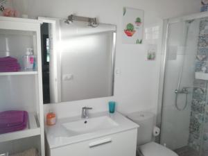 a bathroom with a sink and a toilet and a mirror at Carmencita y Manolito in Telde +18 photos