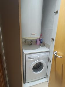 un baño pequeño con lavadora y secadora blancas. en Apartamento a estrenar en A Pobra do Caramiñal en Pobra do Caramiñal