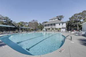 een groot zwembad met stoelen en een huis bij First-Floor Condo Less Than 1 Mi to Sunset Beach Access! in Sunset Beach