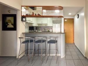 una cocina con 3 taburetes de barra en Apartamento com Vista para o Mar en Guarapari