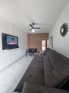 uma sala de estar com um sofá e uma televisão de ecrã plano em Casa nova e confortável próxima ao Santuário em Aparecida