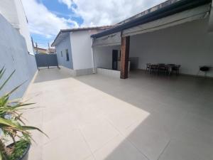 an empty patio with tables and chairs on a building at Casa nova e confortável próxima ao Santuário in Aparecida