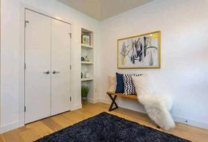 a living room with a bench and a closet at Gem Havana 3 bedroom home in Calgary