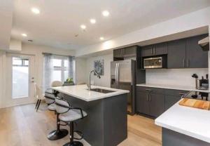 a kitchen with a sink and a refrigerator at Gem Havana 3 bedroom home in Calgary