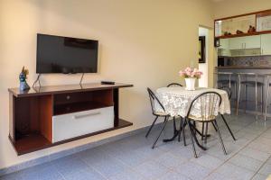 a dining room with a table and a tv at Apartamento com Vista para o Mar in Guarapari