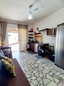 a living room with a kitchen with a stove at Kitinete Girassol 1 - Penha SC - Beto Carrero in Penha