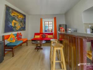 a living room with orange chairs and a bar at Central Plaza Apartments in Cusco