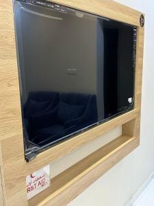 uma televisão de ecrã grande com um assento dentro dela em HOLIDAy فاملي الطائف em Taif