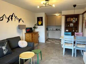 a living room with a couch and a table and a kitchen at Charming Apartment in Laax in Laax