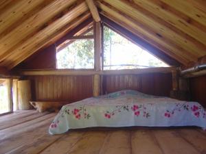 uma cama num quarto de madeira com uma janela em Orgânica-Mente B&B em Viscode de Mauá