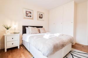 a bedroom with a white bed and a white cabinet at Fantastic 2 Bed London Apartment in London