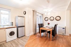 a kitchen and dining room with a table and a refrigerator at Fantastic 2 Bed London Apartment in London