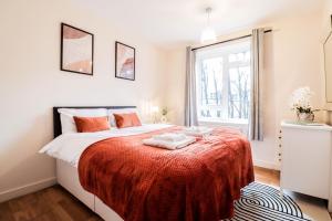 a bedroom with a bed with a red blanket at Fantastic 2 Bed London Apartment in London