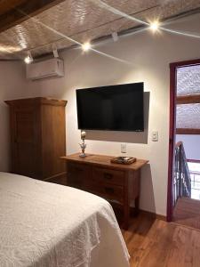 a bedroom with a flat screen tv on a wall at Chafariz Por Um Triz in Tiradentes