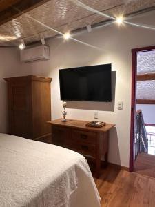 蒂拉登蒂斯的住宿－Chafariz Por Um Triz，卧室配有壁挂式平面电视