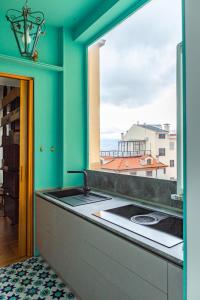 uma cozinha com um lavatório e uma janela em Dimore Santojanni - Il Salotto dei Portici nel centro di Potenza em Potenza