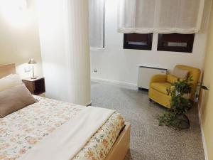 a bedroom with a bed and a yellow chair at Appartamento bilocale tra Venezia e Treviso! in Quarto dʼAltino