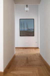 a white room with a painting on the wall at Dimore Santojanni - Il Salotto dei Portici nel centro di Potenza in Potenza