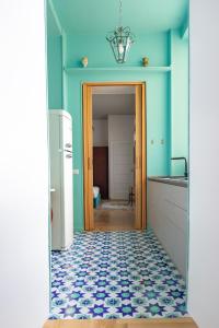uma cozinha com paredes azuis e um piso azul e branco em Dimore Santojanni - Il Salotto dei Portici nel centro di Potenza em Potenza