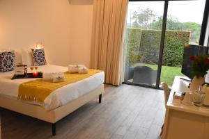 a bedroom with a bed and a large window at Mercedes Country House in Estói