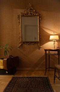 a room with a mirror and a table with a lamp at Dimore Santojanni - Il Salotto dei Portici nel centro di Potenza in Potenza