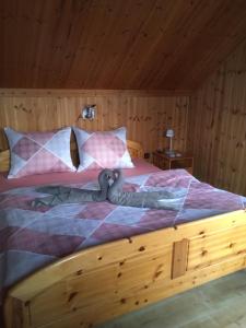 Schlafzimmer mit Holzbett und Holzdecke in der Unterkunft Chata Ujo in Hranice