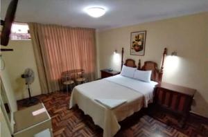 1 dormitorio con 1 cama blanca grande en una habitación en Hospedaje Concordia en Chiclayo
