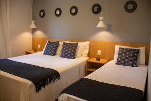 two beds in a room with clocks on the wall at O Recanto Pousada in Serra Negra +116 photos