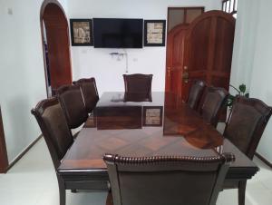 a dining room table with chairs and a television at Casa Maikai Tarapoto in Tarapoto