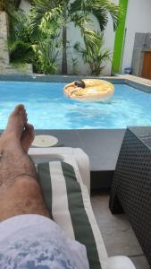 a person laying on a chair in front of a swimming pool at Casa Maikai Tarapoto in Tarapoto
