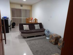 uma sala de estar com um sofá e uma mesa em sobrado 08 com duas suítes, conf no Guarujá
